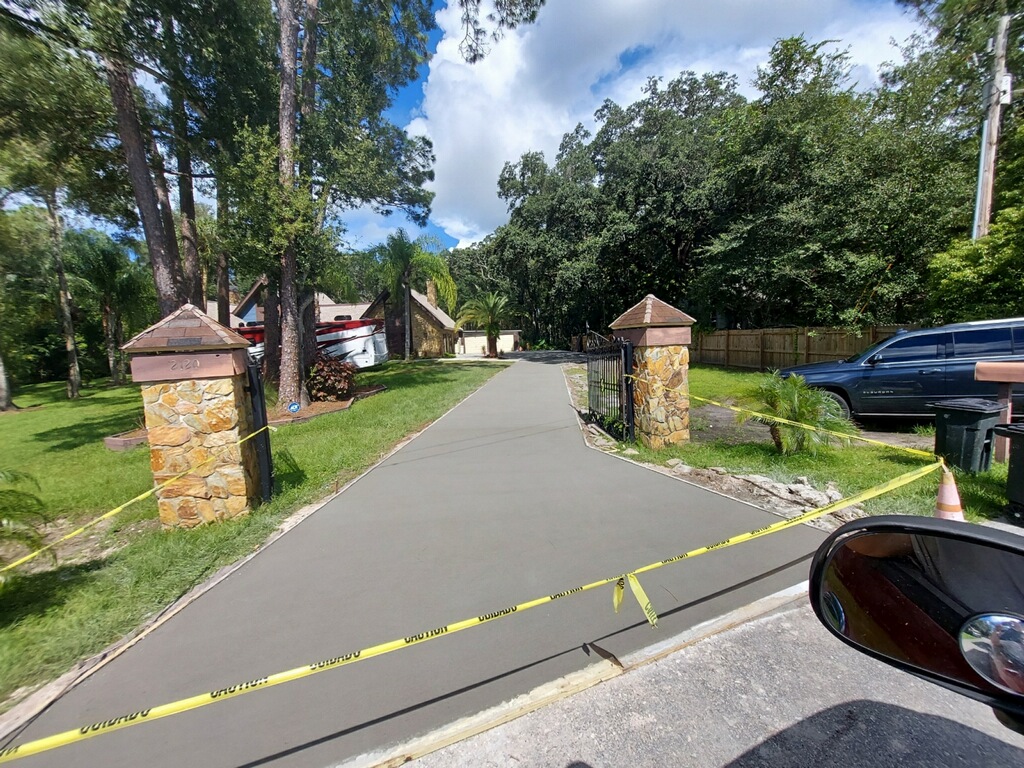 A driveway with yellow tape on the side of it.